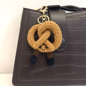 Gehäkelter Brezel-Schlüsselanhänger an brauner Tasche