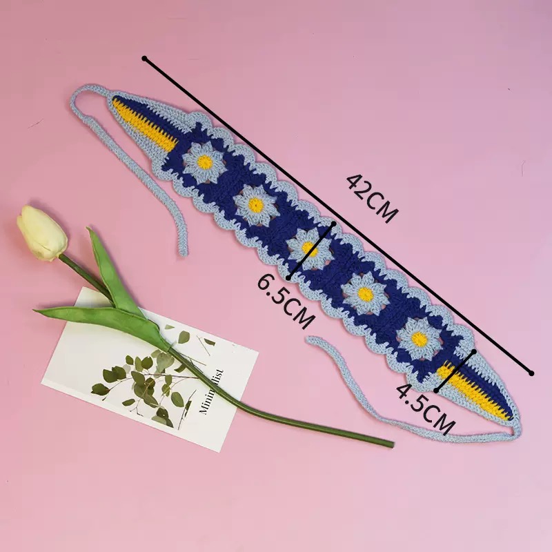 Flach liegendes dunkelblau-hellblaues Haarband mit Gänseblümchen-Muster und Maßangaben 42 cm, 6,5 cm und 4,5 cm auf rosa Hintergrund.