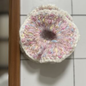 rosa Scrunchie von oben fotografiert, mit weicher Oberfläche, Konfetti-Optik und goldenen Details.
